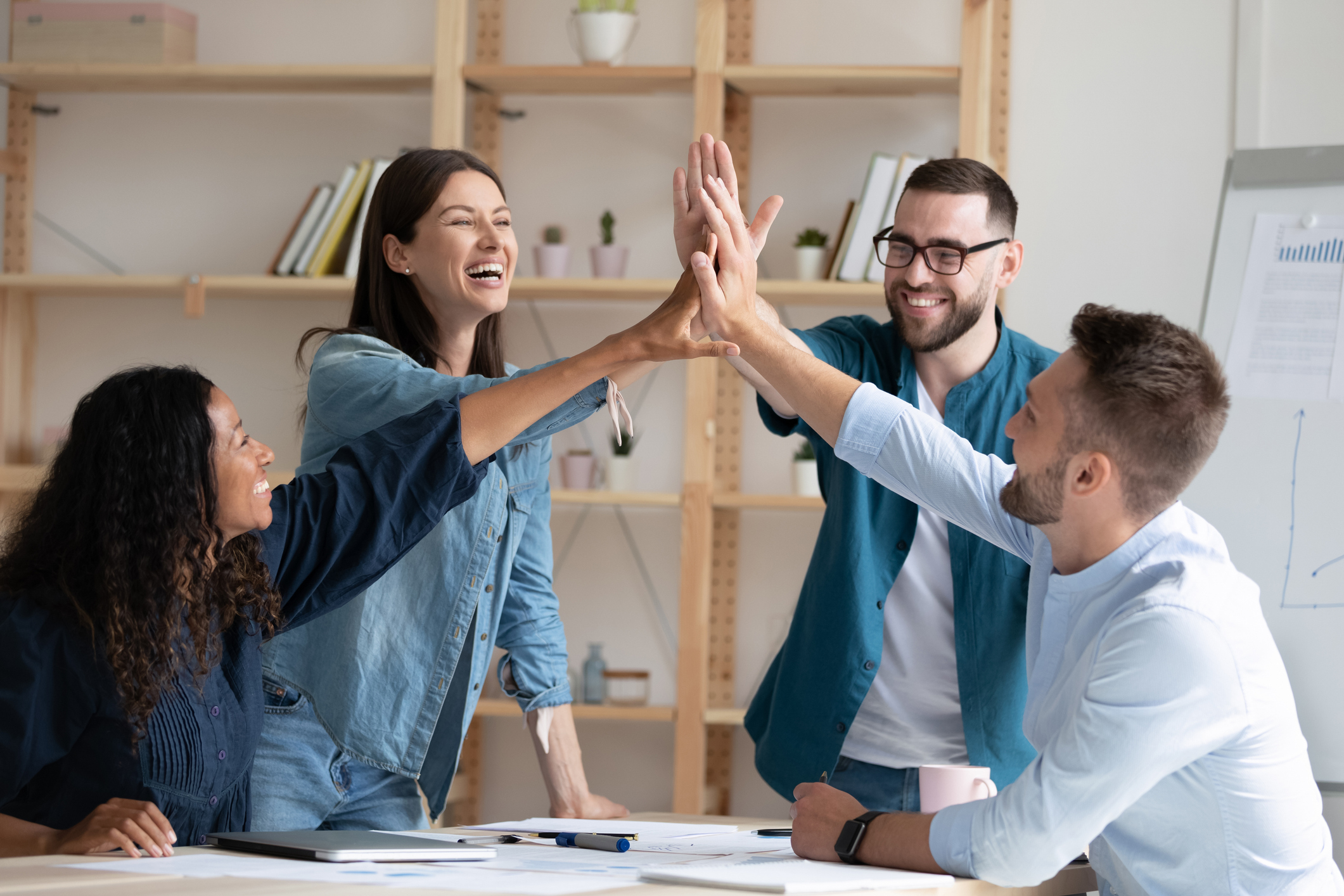 Picture of a group of office workers exchanging high-fives.